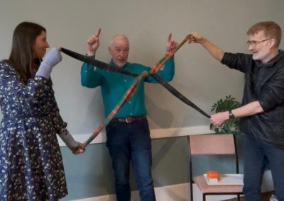 Celebrants demonstrate a tartan handfasting held out in the shape of a cross or Saltire