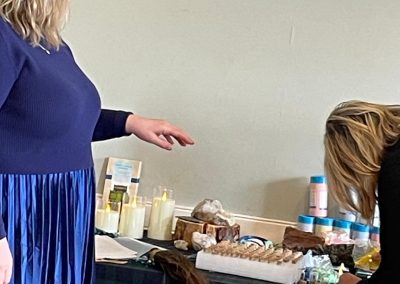 A celebrant gestures to a woman pouring sand into a bottle for a sand ceremony