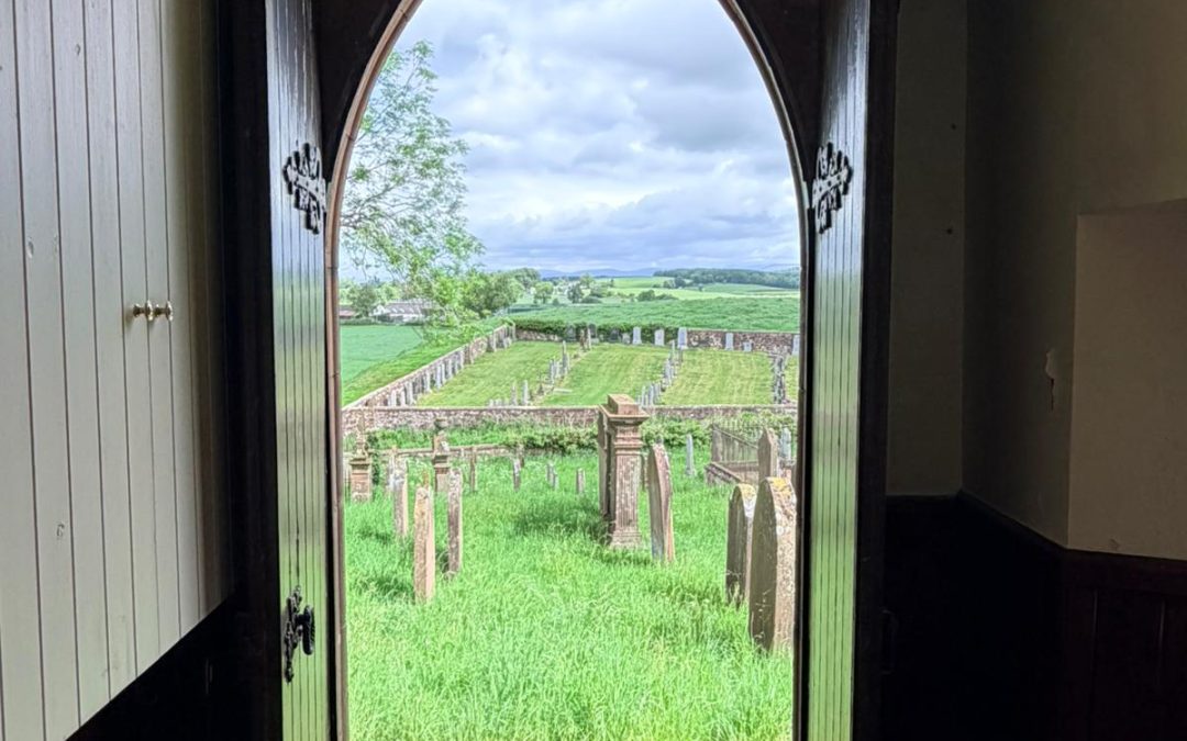 View out of Applegarth Church's door onto the graveyard and fields